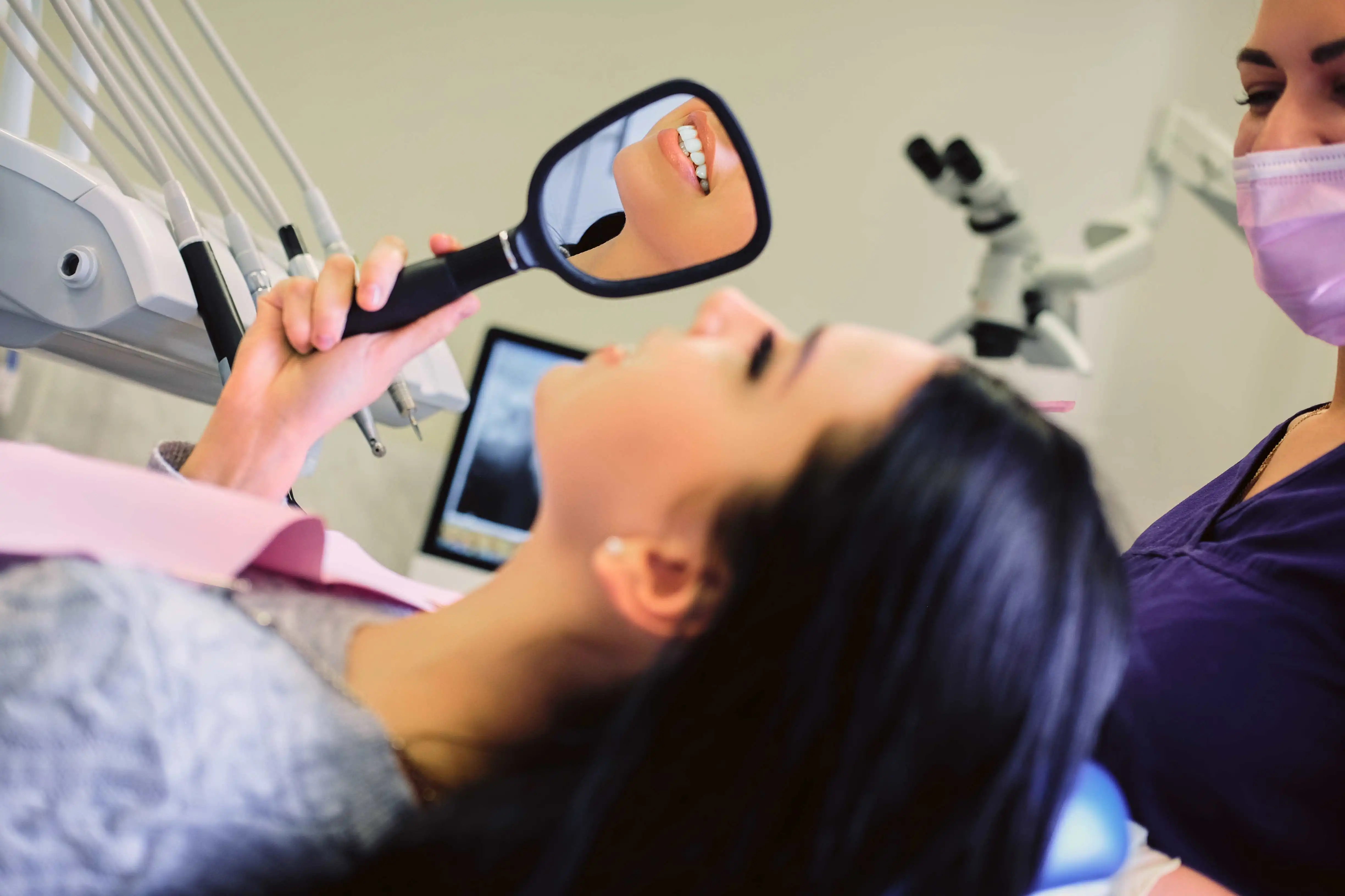 after Bonding Front Teeth female sits in a dentist chair